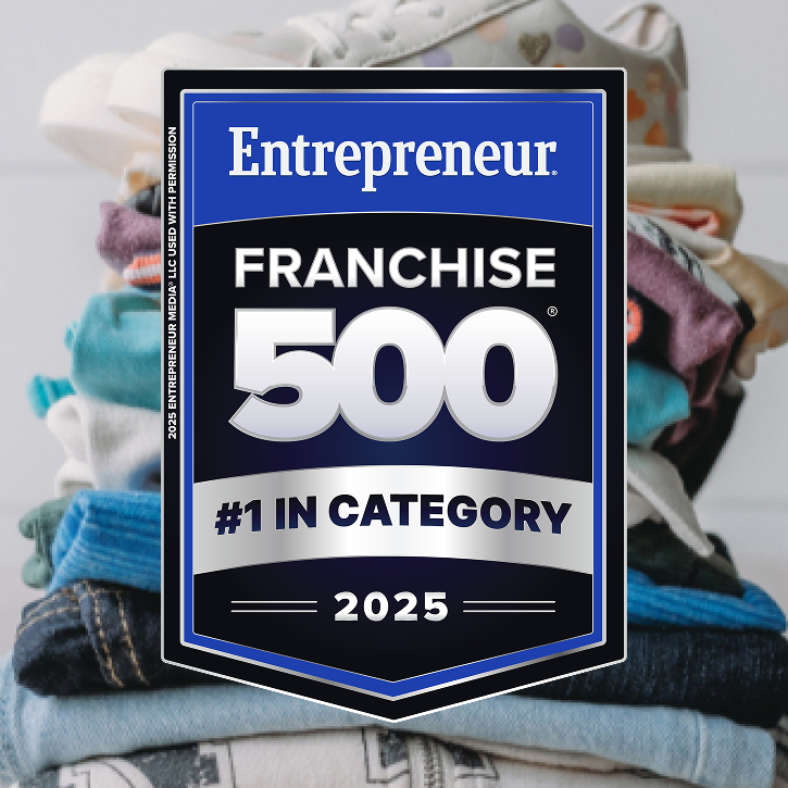 A stack of folded clothes in background with a sign in foreground reading, franchise 500 #1 in category